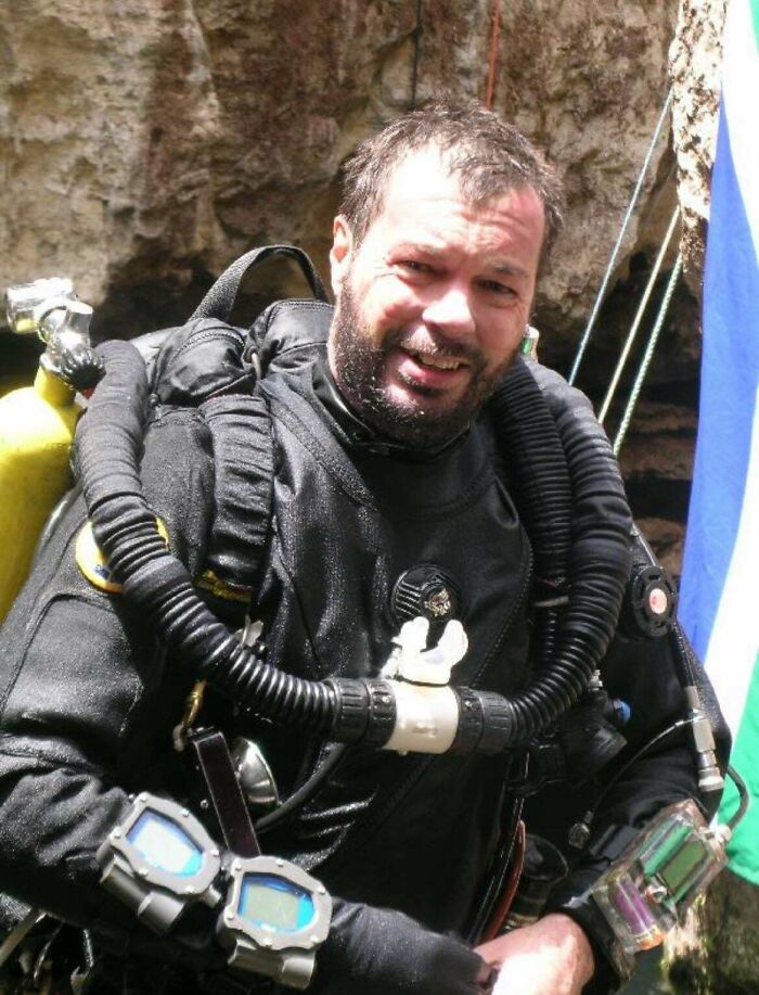 Diver in vintage scuba gear preparing for a deep underwater exploration in a unique historical photo with a deep backstory.
