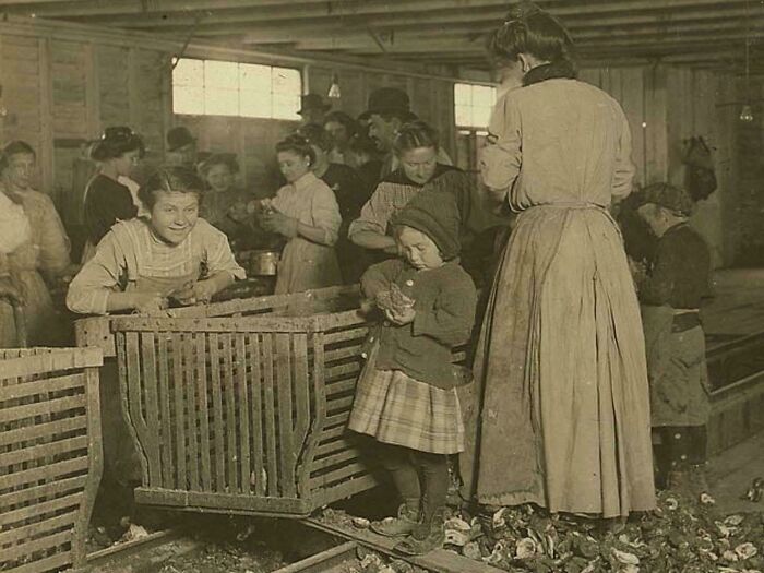 Children and women working with poultry in a rustic setting captured in utterly unique historical photos with deep backstory.