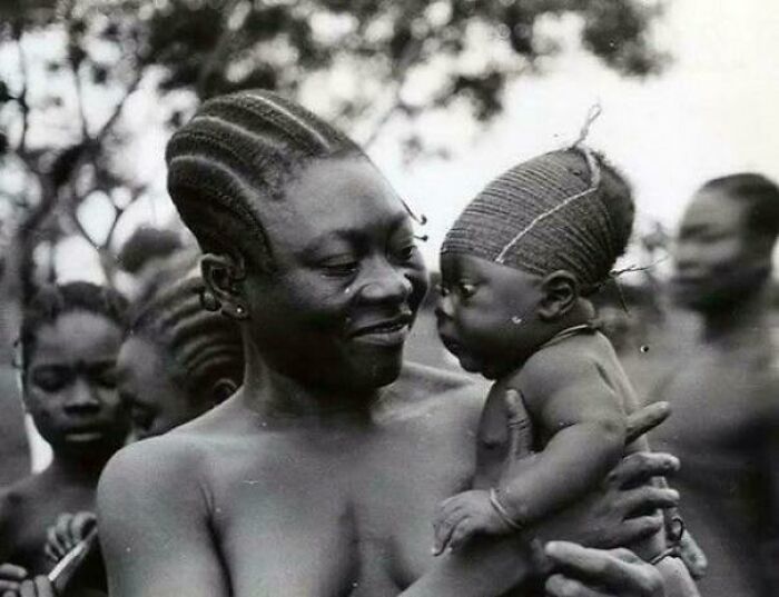 Black and white unique historical photo of a mother holding her baby, showcasing cultural hairstyles and deep backstory.