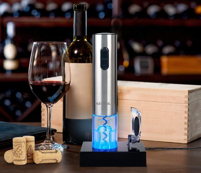 Electric wine opener with rechargeable base and glass of red wine, a popular new kitchen find for wine lovers.