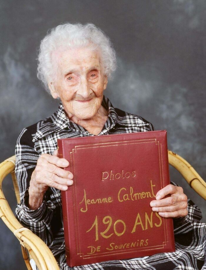 Elderly woman holding a photo album, representing unique historical photos with deep backstory and memories.