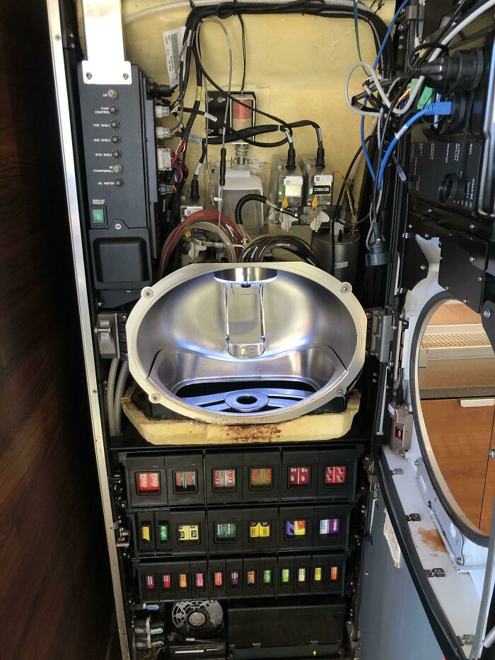 Inside view of a vending machine showing detailed inner components and colorful product selection buttons.