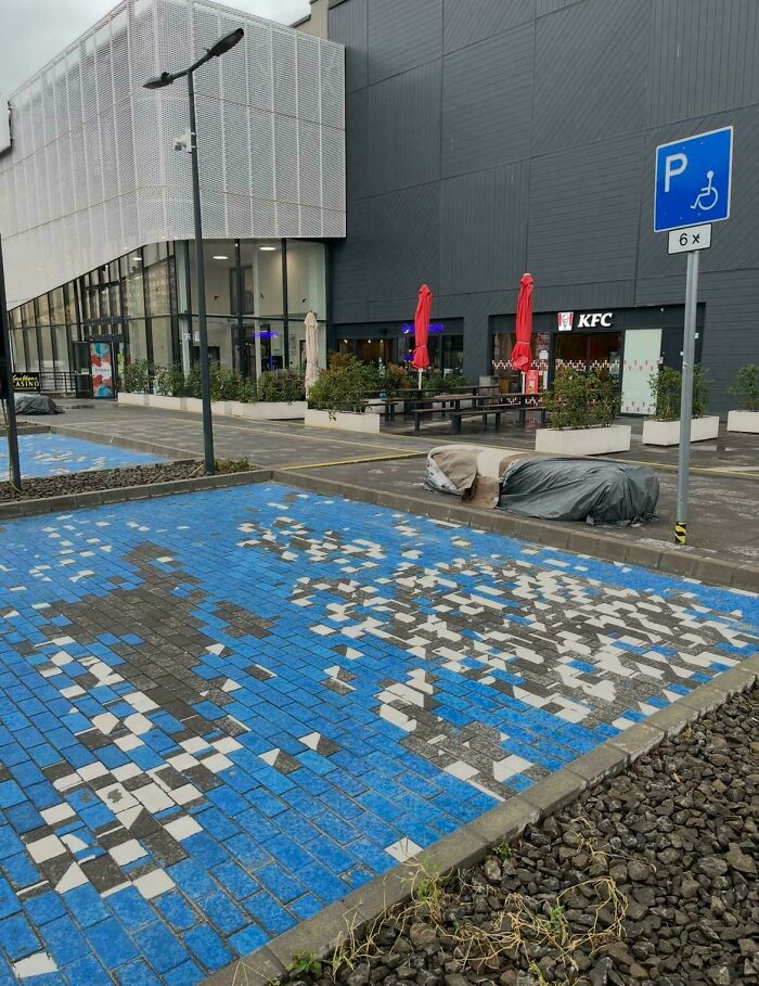 Handicap parking spot with damaged blue and white tiles creating a funny example of people not even trying.