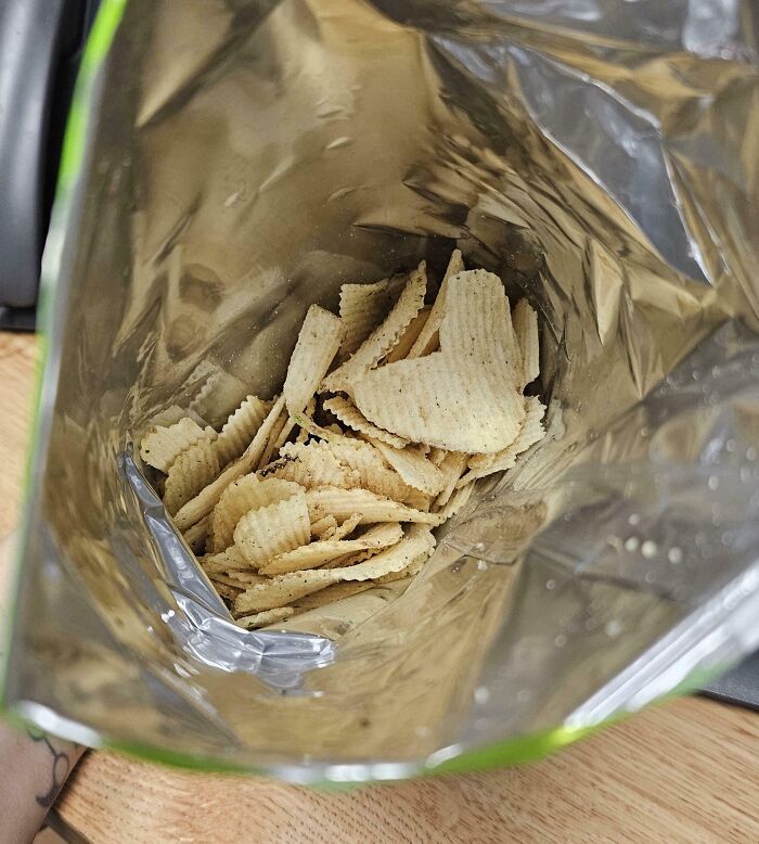 Partially filled bag of potato chips showing misleading packaging with much less product inside than expected.