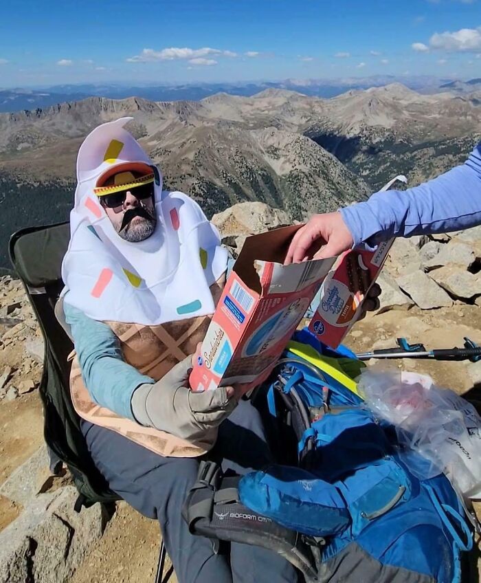 Man dressed as an ice cream cone shares treats with a hiker, uplifting strangers and restoring faith in humanity outdoors.