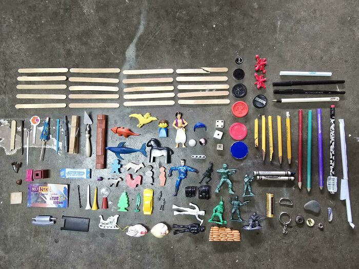 Neatly arranged collection of small toys, pencils, and assorted objects demonstrating satisfying knolled order.