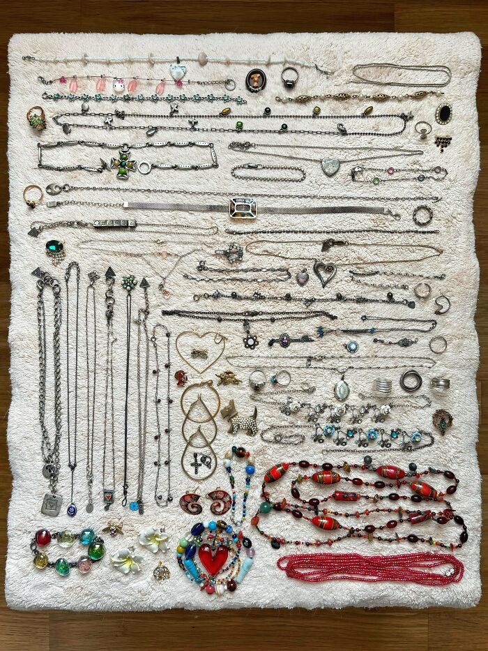 Various necklaces, rings, and bracelets neatly displayed on a white textured surface for order and satisfaction.