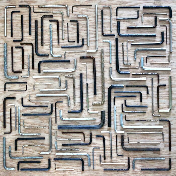 Various sizes of allen wrenches neatly knolled in organized rows on a wooden surface for order and satisfaction.