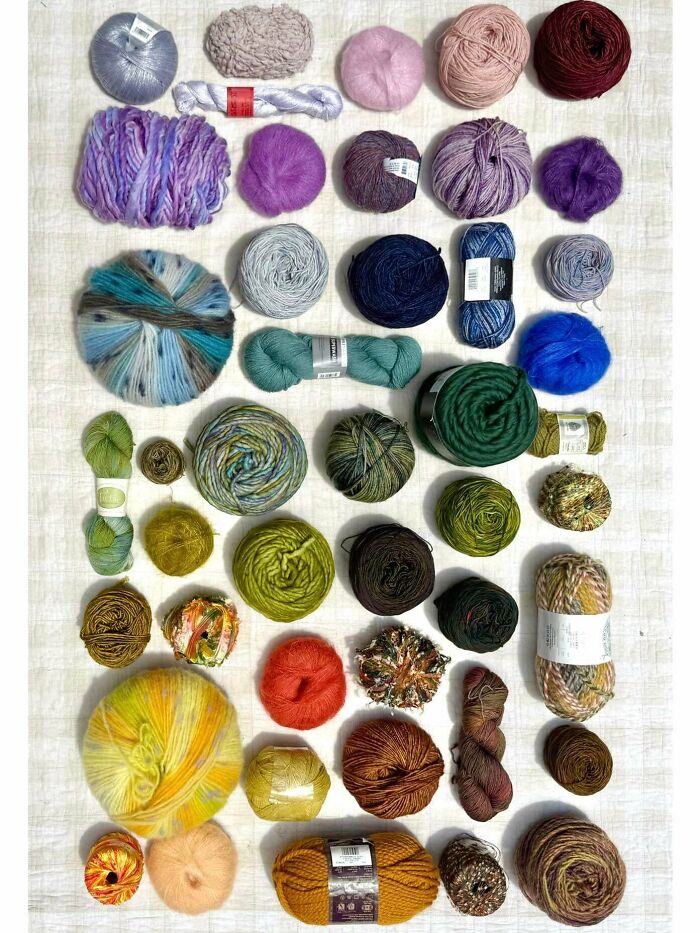 Neatly arranged colorful yarn balls and skeins displayed in an orderly grid, satisfying the need for order and knolled visuals.