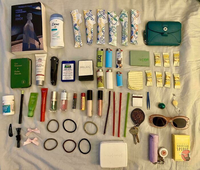 Neatly organized everyday items arranged on a bed, showcasing satisfying and orderly knolled layout.