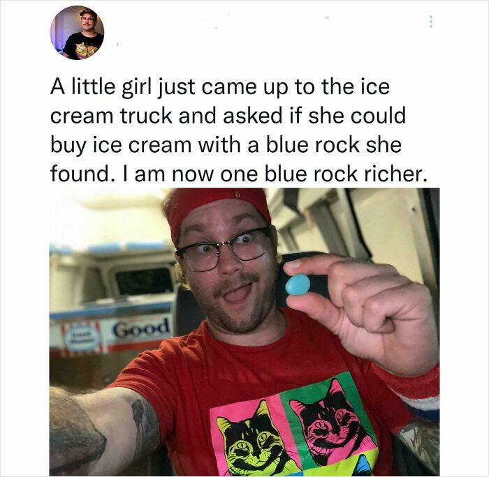 Man in ice cream truck holding a blue rock, smiling after a kind stranger's gesture restoring faith in humanity.