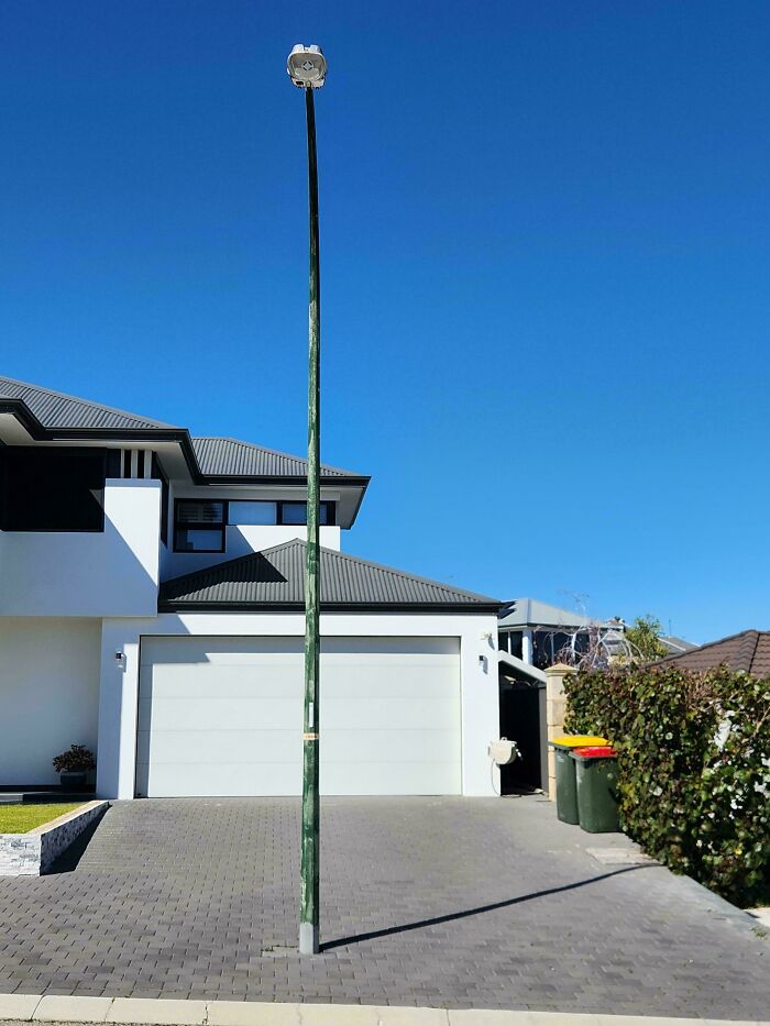 Streetlight installed in the middle of a driveway as a funny example of people not even trying at their job.