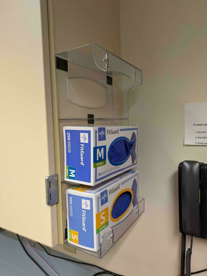 Boxes of FitGuard gloves in medium and small sizes stored in a dispenser, showing a funny example of people not even trying.