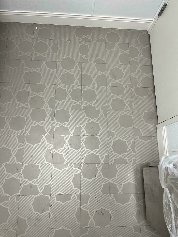 Floor tiles with a mixed pattern that does not align correctly, showing a funny example of people not even trying in their job.