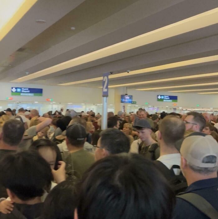 Crowded airport terminal filled with travelers, illustrating faith in humanity restored through acts of kindness among strangers.