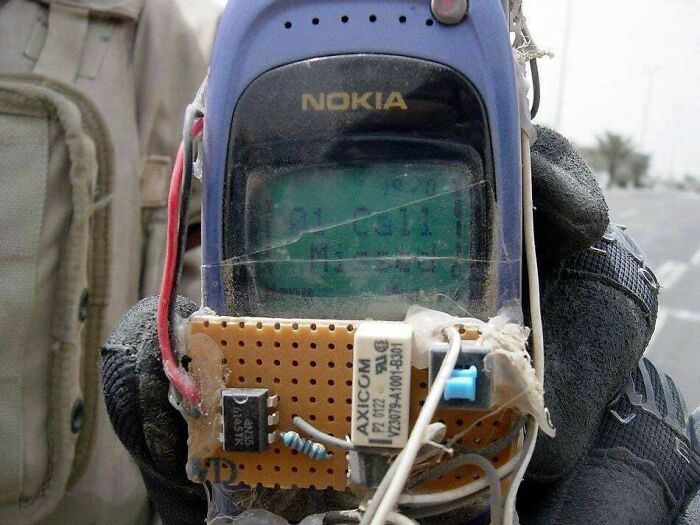 Close-up of a handmade electronic device attached to a Nokia phone, showing frozen frames without aftermath.