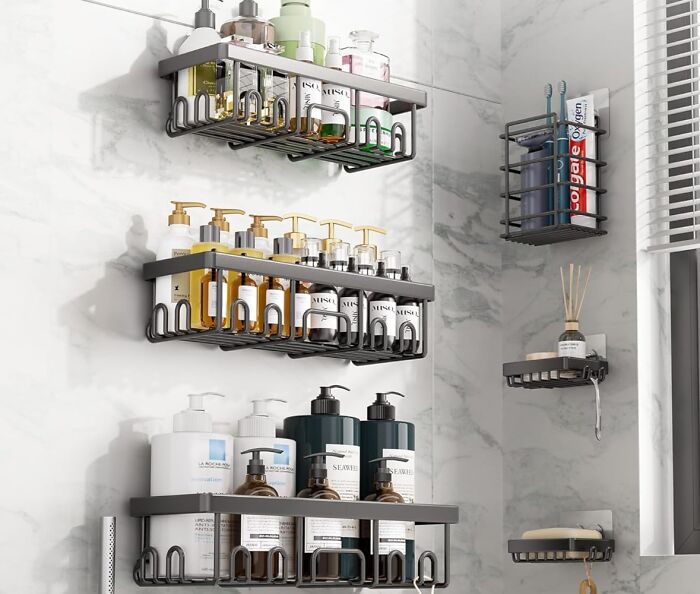 Bathroom wall-mounted shelves with various toiletries and personal care products neatly organized on gray racks.