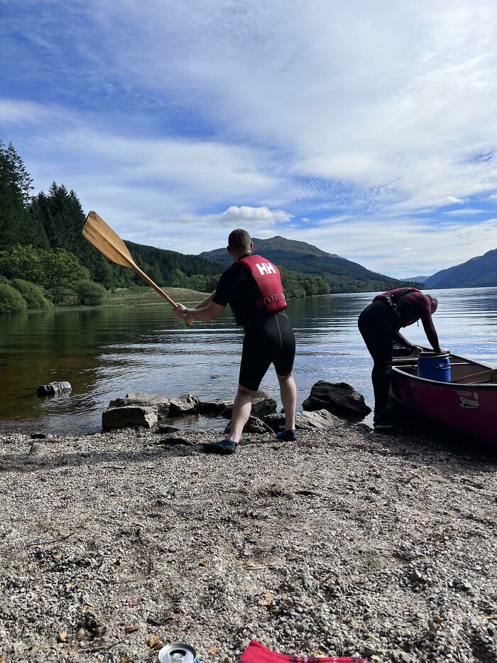 Two people preparing a canoe on the lake shore in a frozen frame capturing adventure and outdoor moments.