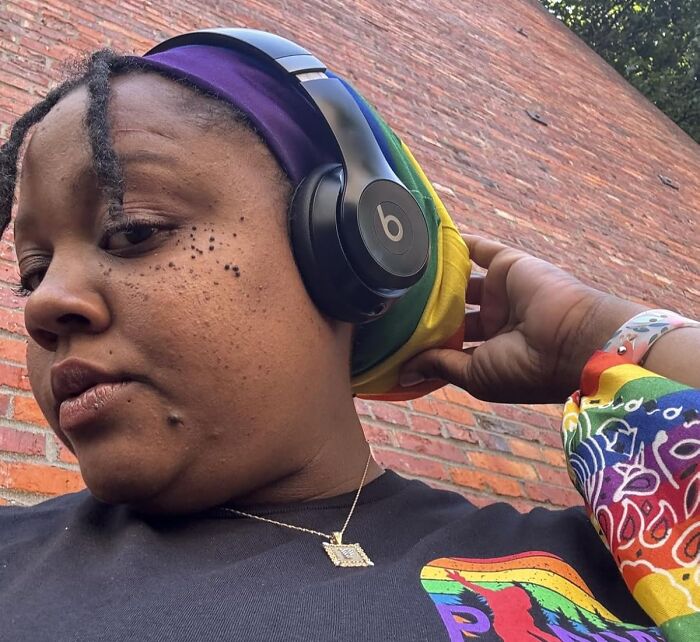 Person wearing colorful headscarf and black Beats headphones outdoors, showcasing style while enjoying 11.11 deals.