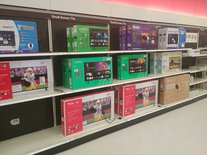 Shelves stocked with various small-screen TVs and electronics during Black Friday shopping event.