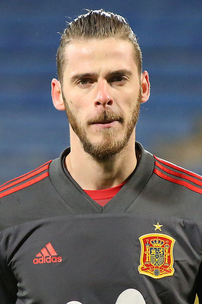 David de Gea in Spain national team jersey, focused during a soccer match, showcasing his career as a goalkeeper.