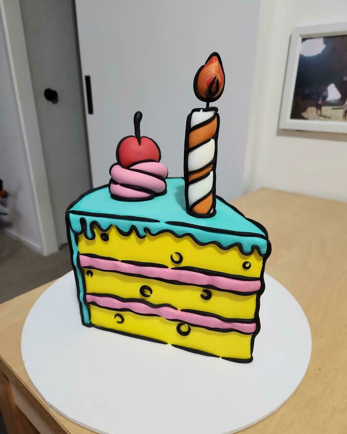 Cartoon-style creative cake project with bright colors, decorated with a cherry and a striped candle on top.
