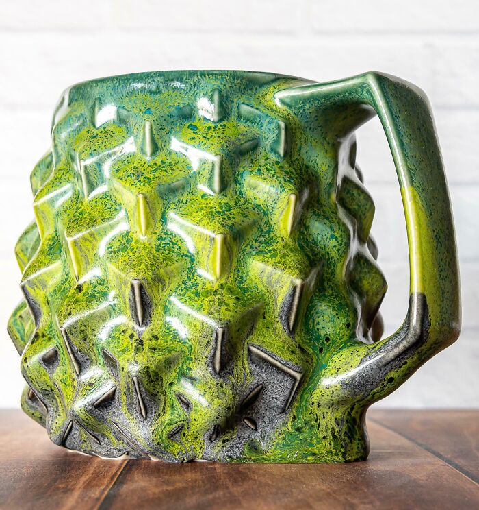 Green and black textured ceramic mug with geometric patterns, showcasing creative design and unique artistic project.