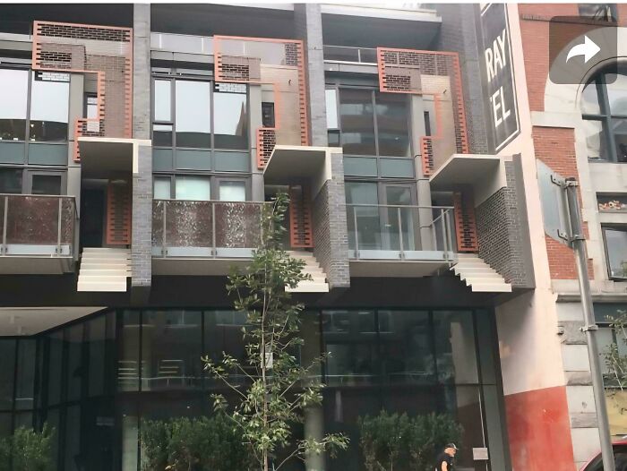 Modern building facade with multiple external staircases, highlighting Airbnb insanity and the need for insurance on steep stairs.