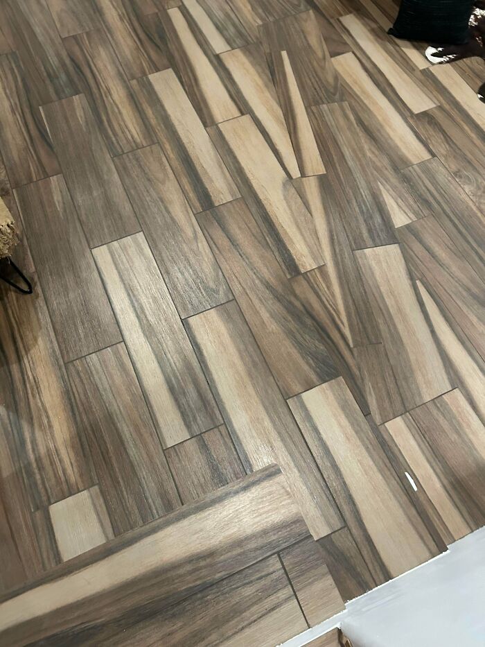 Distorted wooden floor tiles with uneven alignment, highlighting potential hazards related to Airbnb insurance concerns.