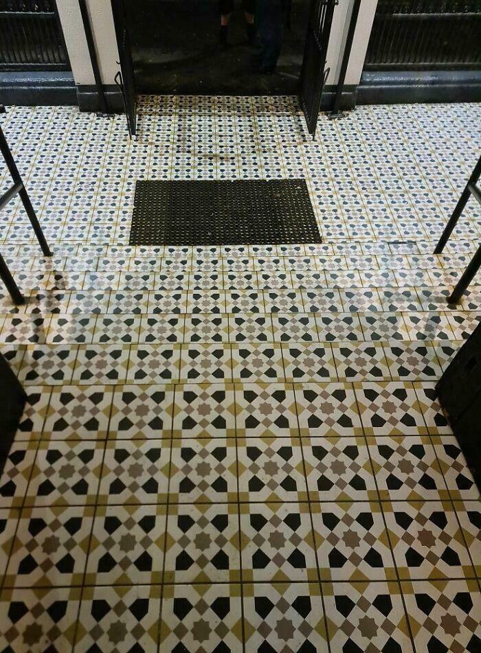 Patterned tiled stairs leading up to a doorway with a black mat, illustrating Airbnb stairs needing insurance protection.