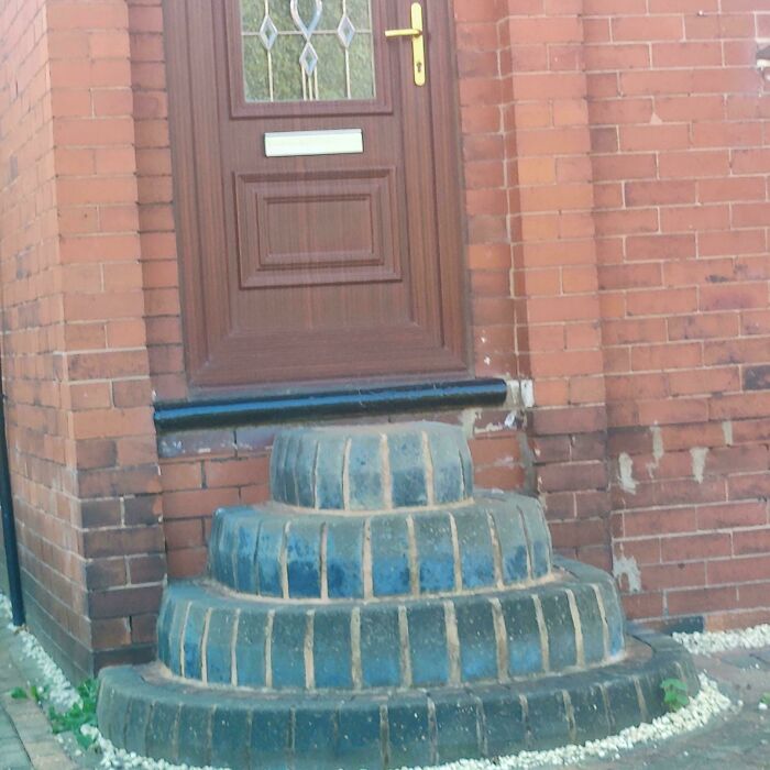 Circular brick stairs leading up to a brown door on a red brick building, highlighting Airbnb insurance concerns.