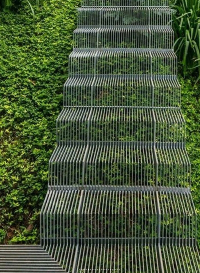 Metal staircase with an unusual design surrounded by greenery, highlighting Airbnb insurance and staircase safety concerns.