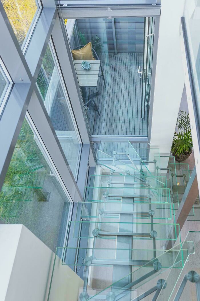Modern glass stairs in a bright space leading to a deck, highlighting Airbnb risks and need for proper insurance.