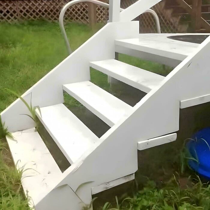 White outdoor staircase with uneven steps in a grassy yard, highlighting Airbnb stairs insurance risk and safety concerns.