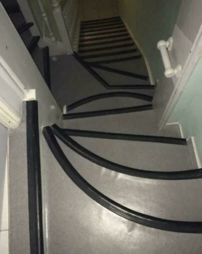 Steep and narrow stairs with sharp turns in an Airbnb rental, highlighting the need for insurance and caution.