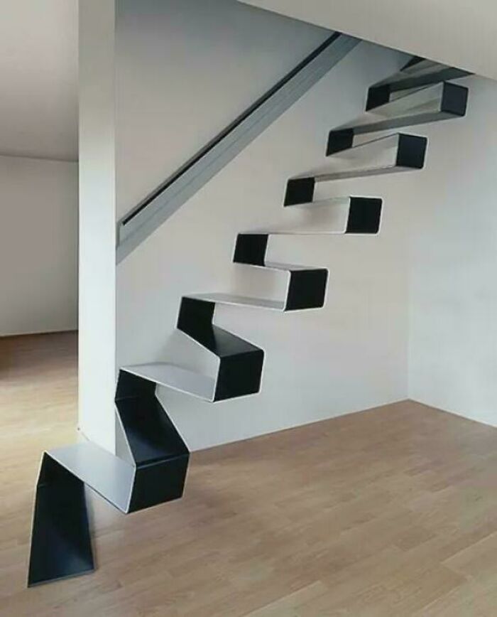 Modern black and white zigzag floating stairs in a minimalist room representing Airbnb insanity stairs concept.