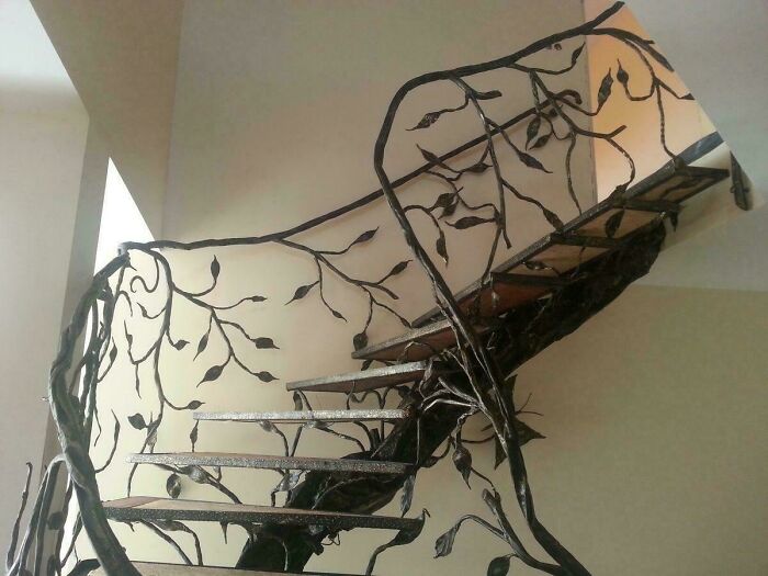 Wrought iron spiral staircase with intricate leaf designs, illustrating Airbnb stairs needing insurance for safety concerns.