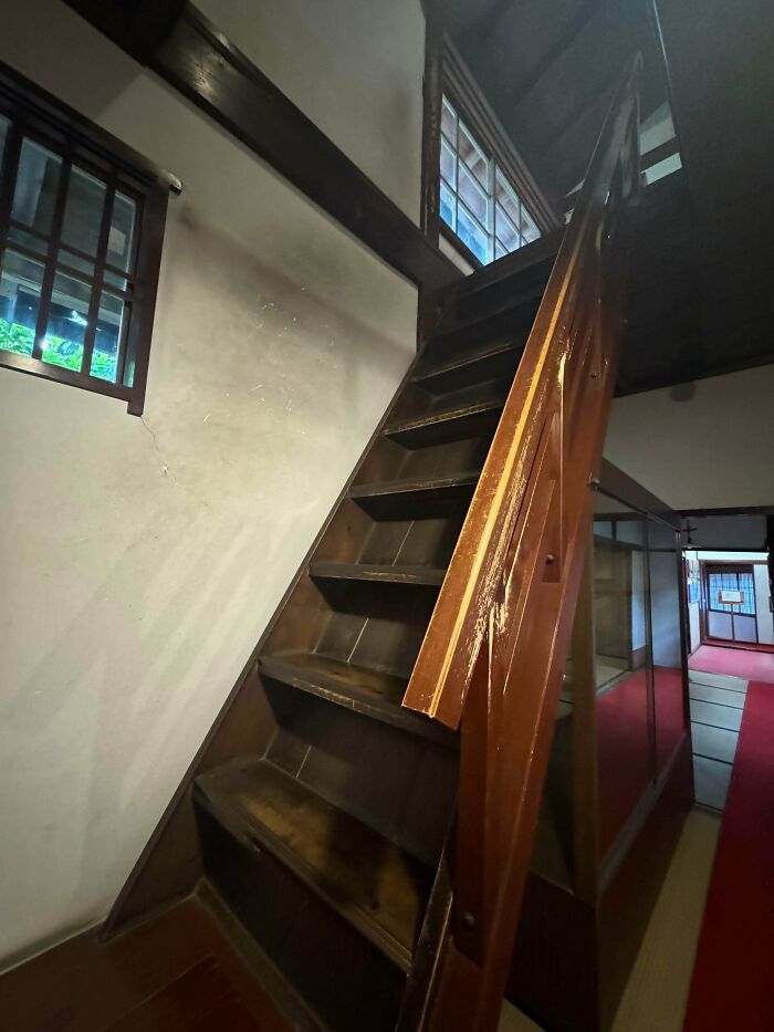 Steep wooden stairs inside an old building, highlighting the risk factor related to Airbnb insurance and safety concerns.