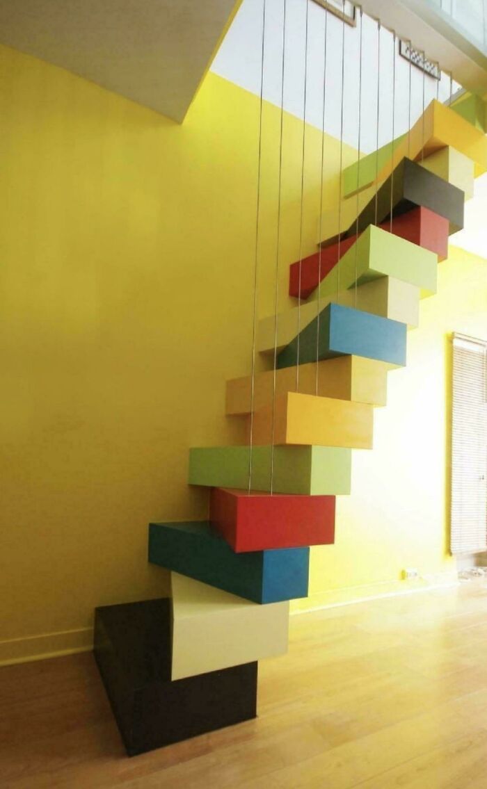Colorful suspended staircase with 130 stairs in a modern interior highlighting Airbnb insanity and insurance risks.