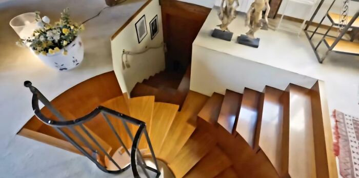 Wooden spiral staircase in a modern Airbnb rental, highlighting the importance of insurance for safety on multiple stairs.