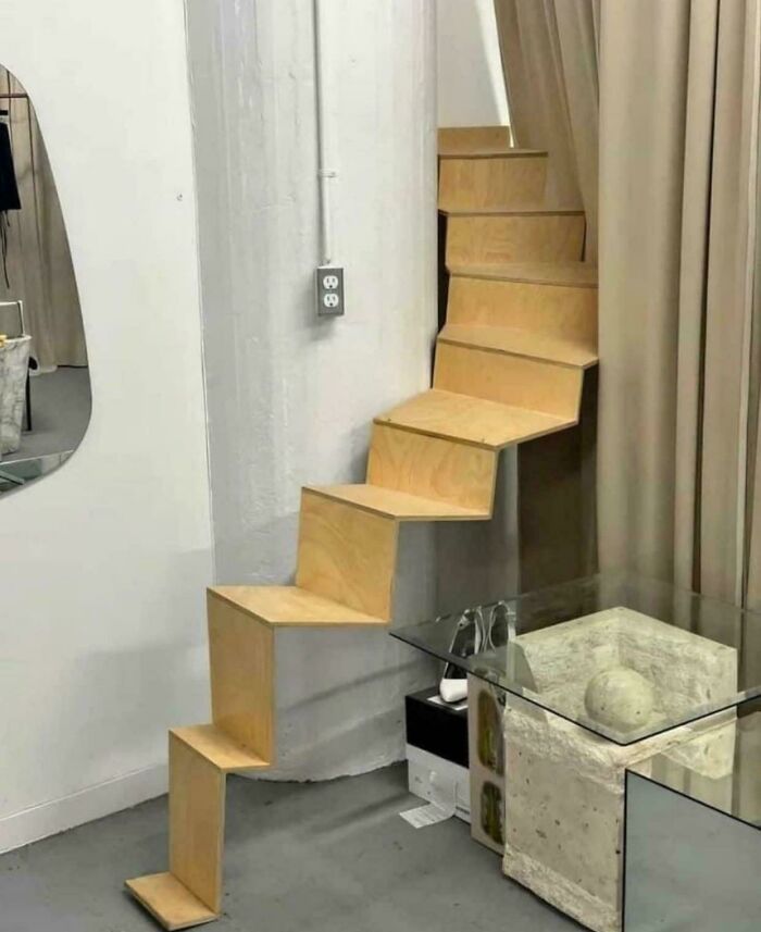 Steep indoor wooden stairs with sharp angles in a modern room, highlighting Airbnb insurance safety concerns.