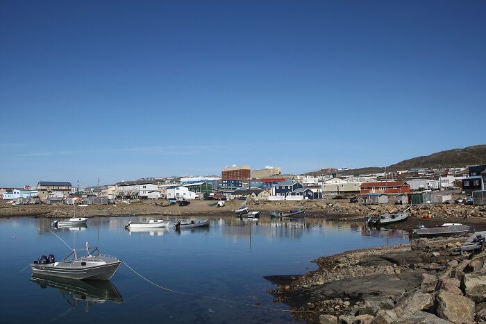 Calm coastal village with boats docked in the water, showcasing one of the mind-blowing remote locations.