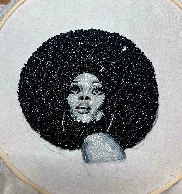 Beaded embroidery portrait of a woman with an afro, showcasing creative people and cool projects in detailed beadwork.