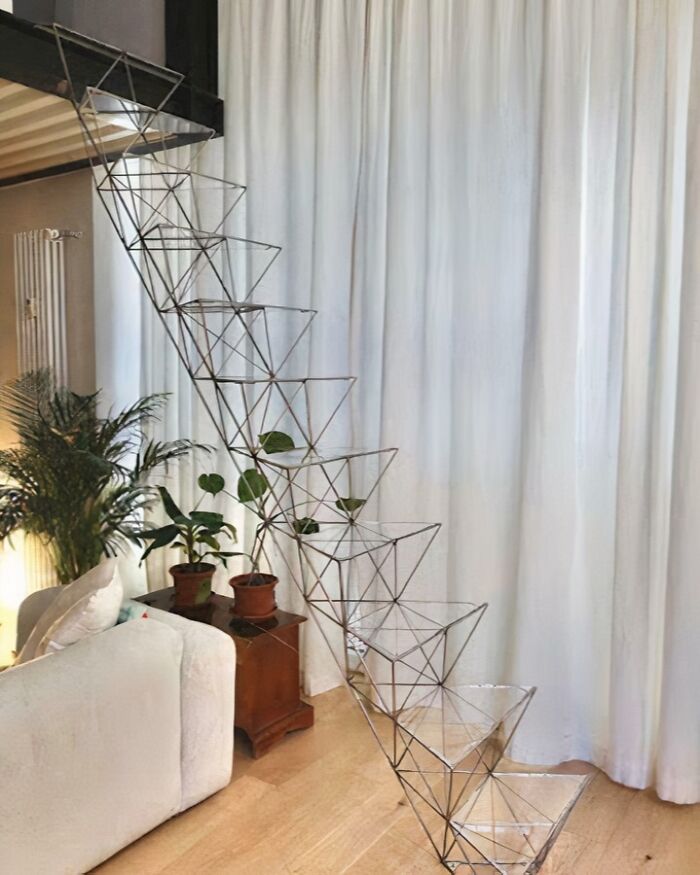 Unique metal staircase inside a modern living space highlighting Airbnb insanity with 130 stairs needing insurance.