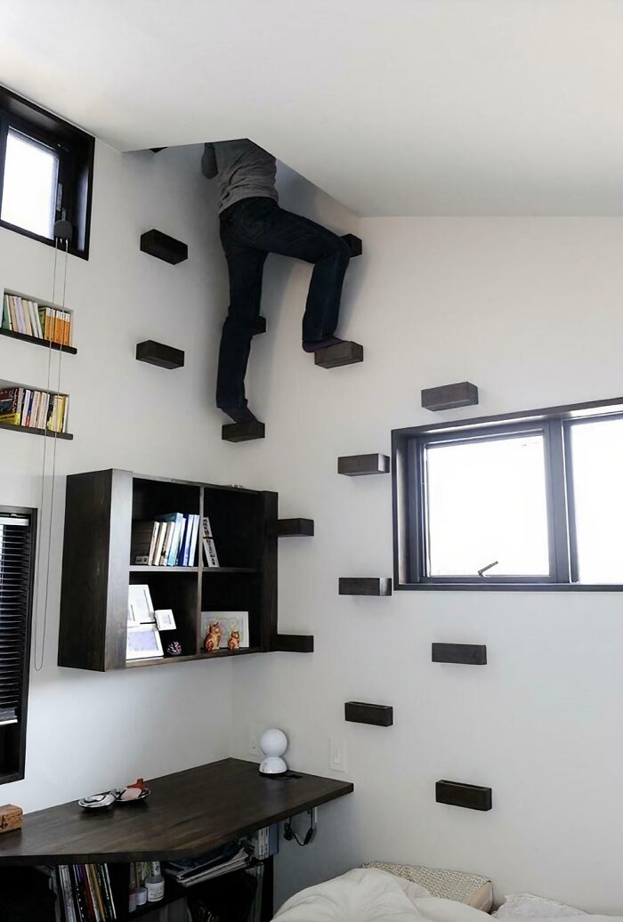 Person climbing unusual wall-mounted stairs inside a modern room, illustrating Airbnb Insanity with risky stair design.