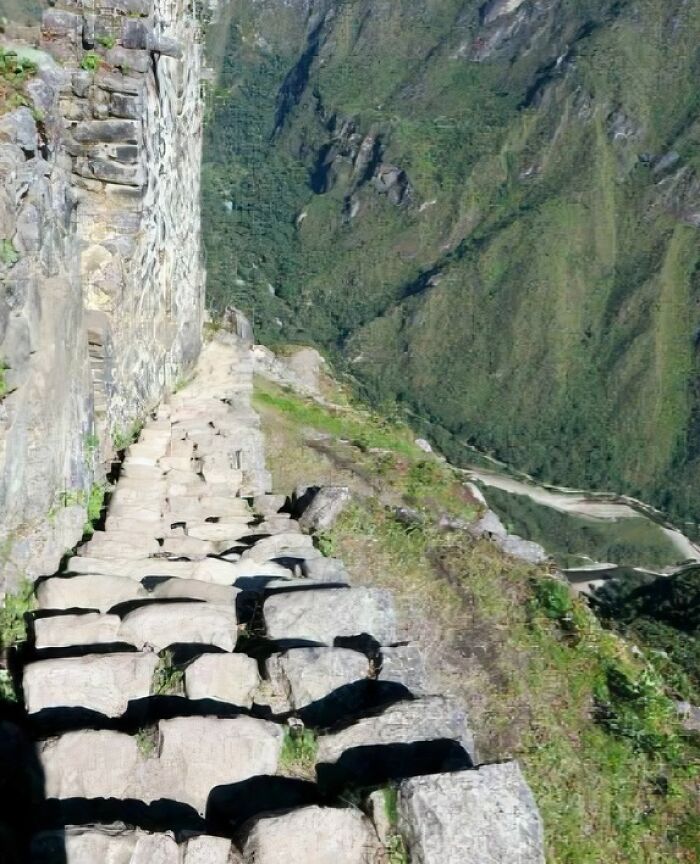 Steep stone stairs descending along a mountain cliff, illustrating Airbnb insanity and the need for insurance on risky stairs.