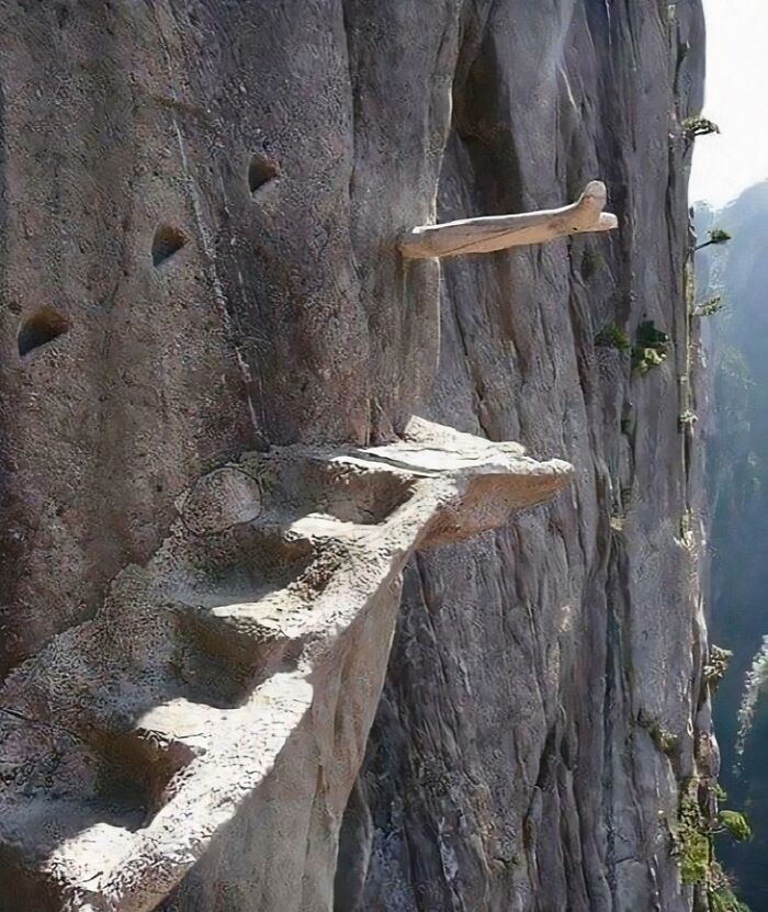 Steep and narrow rock stairs carved into a cliffside, highlighting airbnb insanity with risky stairway access.