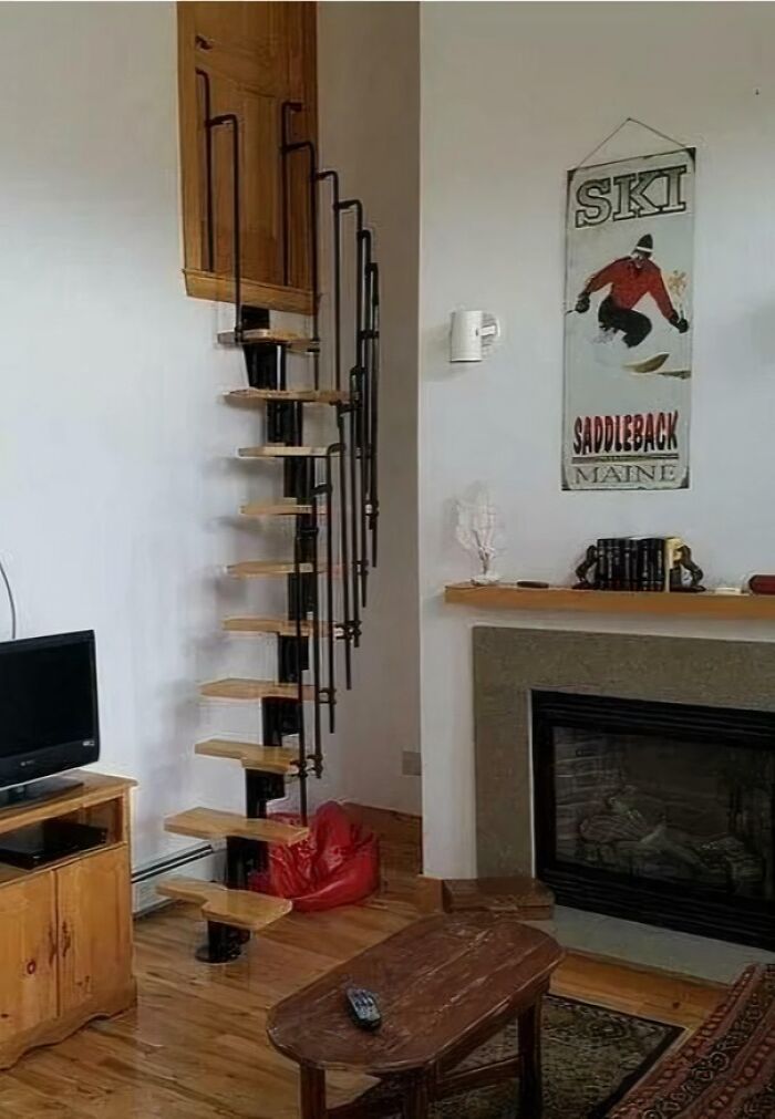 Narrow spiral staircase with wooden steps inside a living room, highlighting Airbnb stairs insurance concerns.