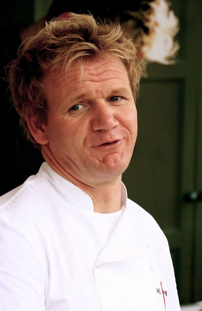 Gordon Ramsay in a white chef jacket, captured in a candid moment highlighting his culinary career.