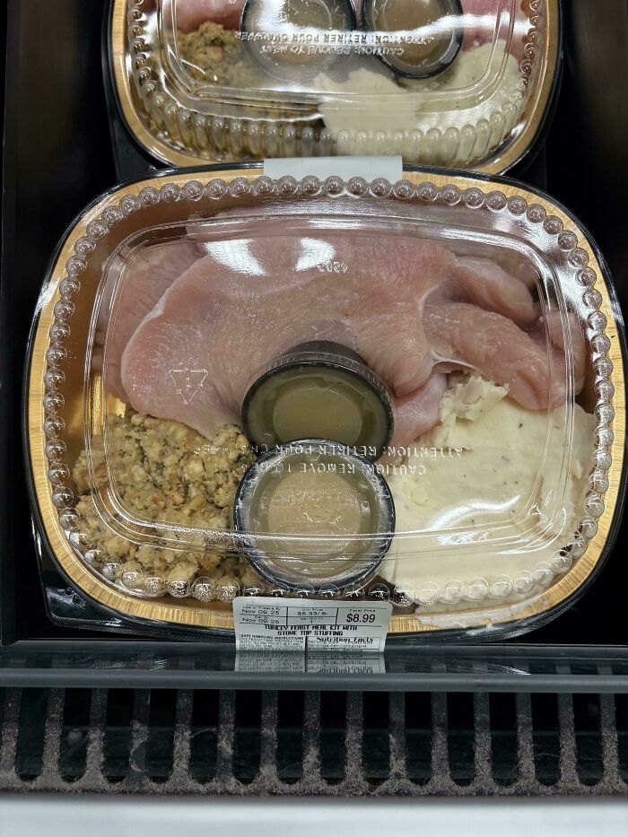 Prepackaged raw turkey with stuffing and mashed potatoes in plastic container, showing a strange food presentation.